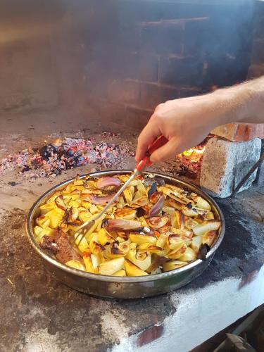a person is cooking a pizza on a grill at Pansion Jakas in Zavala