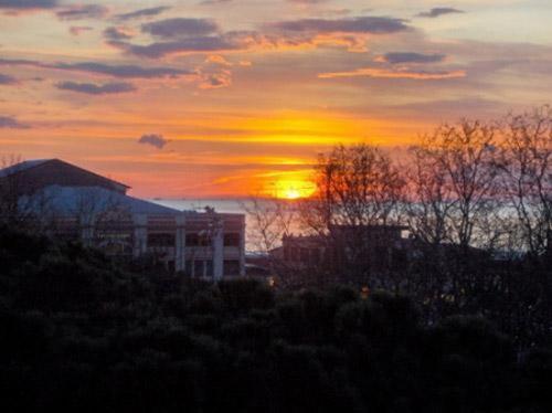 a sunset with the sun setting in the background at Hotel Firenze in Viareggio