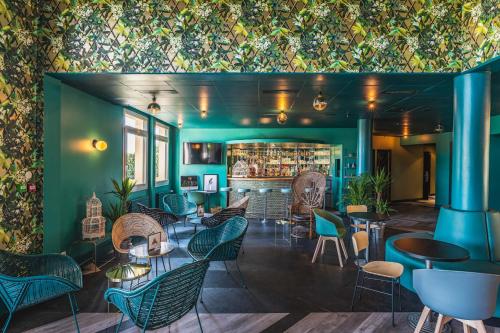 a restaurant with green walls and chairs and a bar at Best Western Hôtel Grand Parc Marne La Vallée in Chanteloup-en-Brie