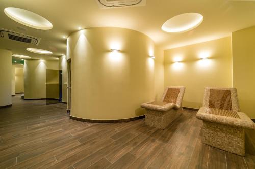 a waiting room with two chairs in front of a wall at Unique - Resort and SPA in Ohrid