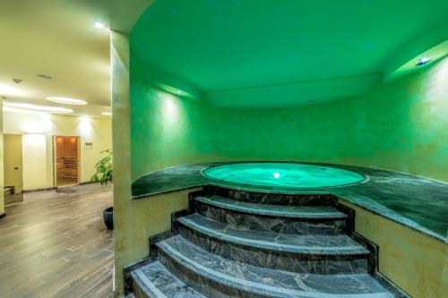 a jacuzzi in a room with a green wall at Unique - Resort and SPA in Ohrid