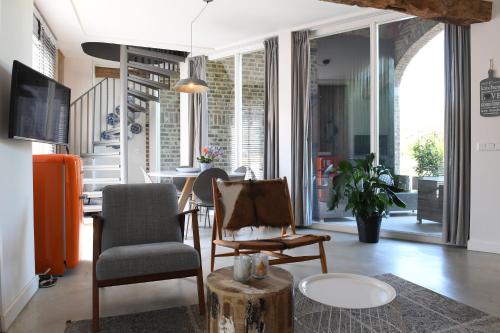 a living room with a chair and a table at Vakantiewoningen - Buitenverblijf Huiskenshof Zuid-Limburg in Klimmen