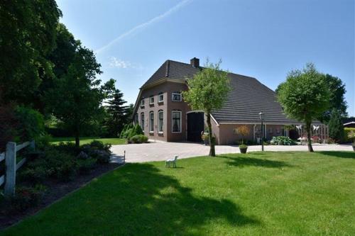 a large house with a grassy yard in front of it at B&B Schoonloo - boerderij appartementen in Schoonloo