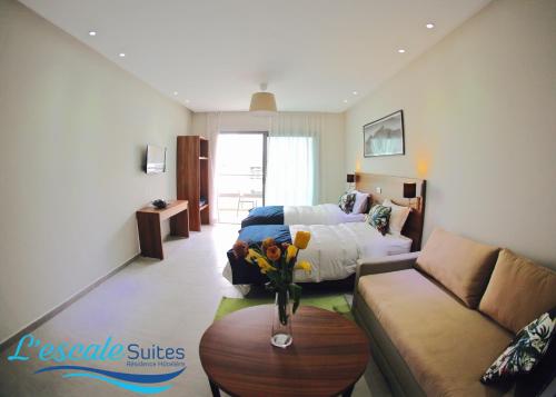 a room with a bed and a couch and a table at L'escale Suites Résidence Hôtelière By 7AV HOTELS in Mohammedia
