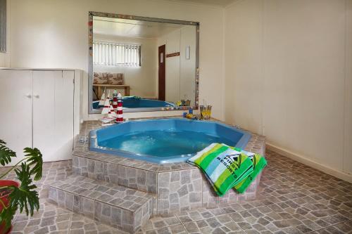 ein Badezimmer mit Whirlpool-Badewanne im Zimmer in der Unterkunft First Group Kowie River Chalets in Port Alfred