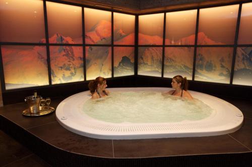 two women in a hot tub in a hotel room at Hotel Le Samoyede in Morzine