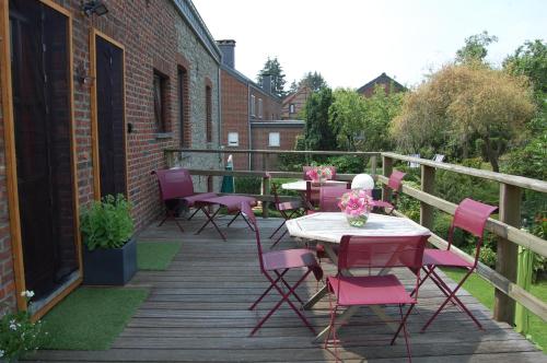 a patio with pink chairs and tables on a deck at Appartement Fleurs des champs - Esc'Appart in Rochefort