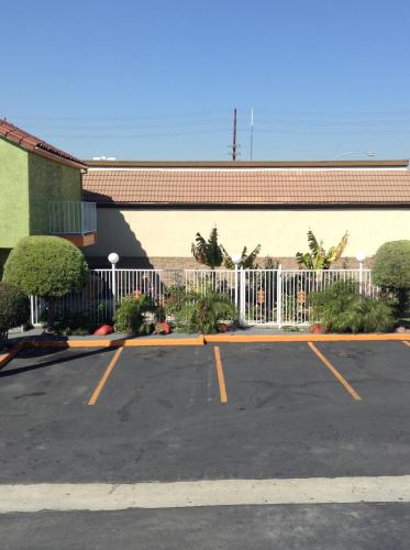a parking lot in front of a building with a fence at Big A Motel in Orange