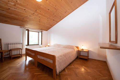 een slaapkamer met een bed en een houten plafond bij Apartments Stella in Opatija