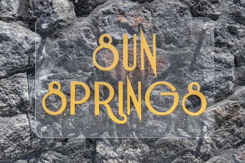 a sign that says sun orange on a stone wall at Sun Springs Suites in Kamari