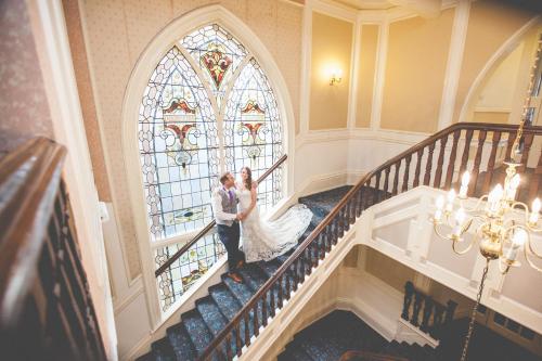 a bride and groom on the stairs of a building at Cairn Hotel in Harrogate
