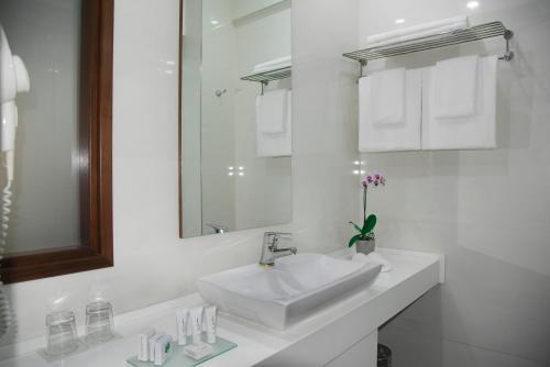 a white bathroom with a sink and a mirror at City5 ROOMS & SUITES by LSA in Skopje