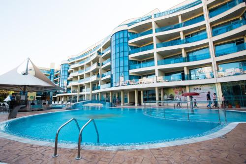 a large swimming pool in front of a building at Aparthotel Marina Holiday Club & SPA - All Inclusive & Free Parking in Pomorie