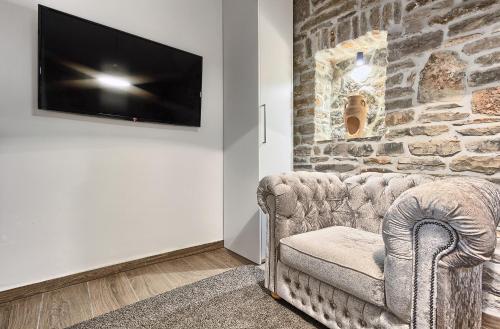 a living room with a couch and a tv on a wall at Golden Haven in Murter