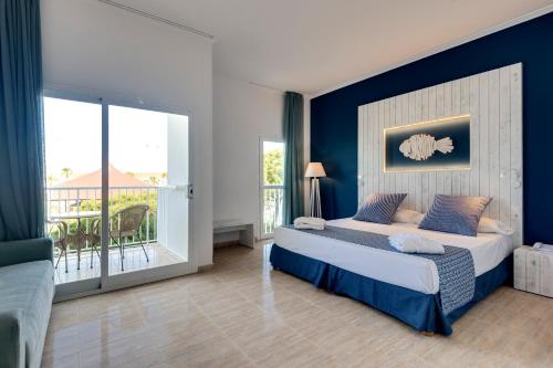 1 dormitorio con 1 cama grande y balcón en Garden Playanatural - Adults Only, en El Rompido