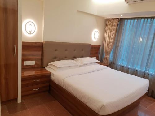 a bedroom with a large bed and a window at Hotel Milan International in Mumbai