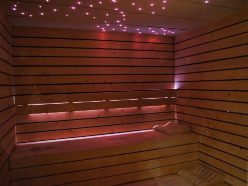 a sauna with pink lights on a wooden wall at La Villa Mazarin in Aigues-Mortes