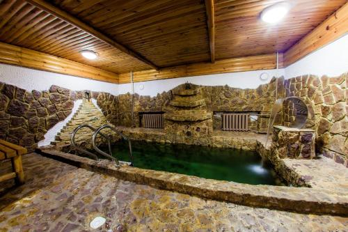 a large pool of water in a room with a stone wall at Hotel Edem in Karagandy