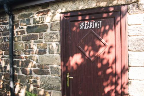 a brown door with the word breakfast written on it at Fernhill Hotel in Rochdale