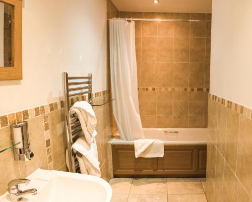 a bathroom with a sink and a shower and a tub at Fernhill Bed and Breakfast in Rochdale