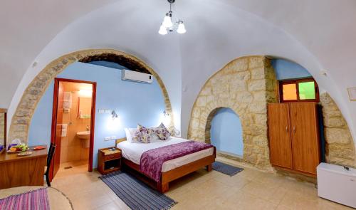 a bedroom with a bed and a bathroom with a sink at Dar Sitti Aziza in Bethlehem
