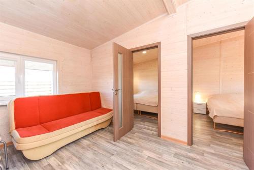 a room with a orange couch and a bedroom at Ardonas in Šventoji