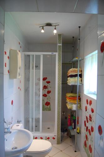 La salle de bains est pourvue d'un lavabo, d'une douche et de toilettes. dans l'établissement Domek myśliwski, à Gietrzwałd