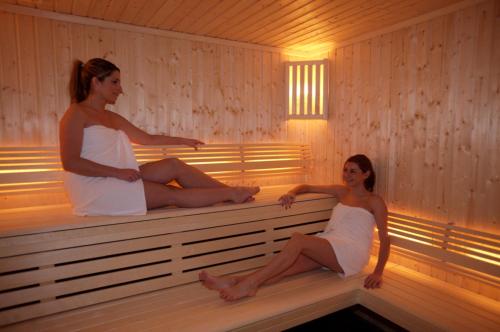 two women are sitting in a sauna at Hotel Le Samoyede in Morzine