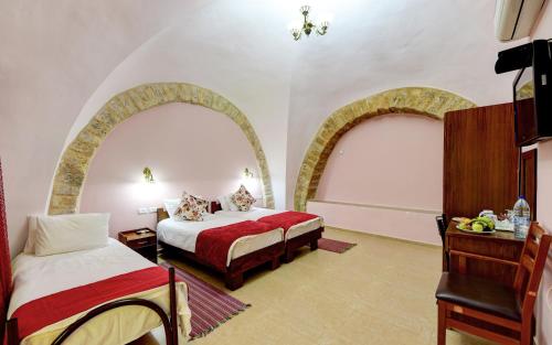 a hotel room with two beds and two windows at Dar Sitti Aziza in Bethlehem