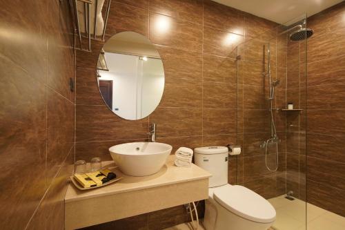 La salle de bains est pourvue de toilettes, d'un lavabo et d'un miroir. dans l'établissement Hovi Hoang Cau 3 - My Hotel, à Hanoï