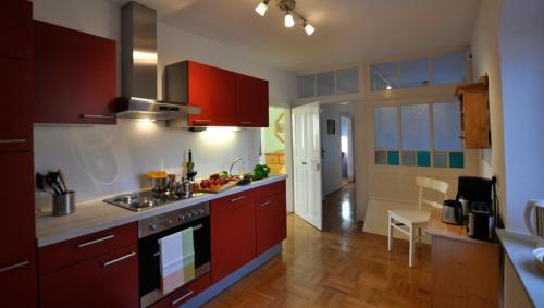a kitchen with red cabinets and a stove top oven at Landhausgarten Bunzmann in Berg