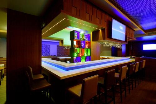 a bar in a restaurant with chairs and lights at The Central Residency in Trivandrum