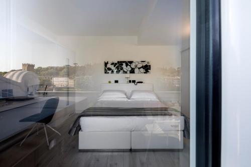 a white bedroom with a bed and a desk at LHP Hotel River & SPA in Florence