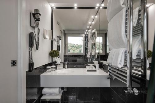 a bathroom with a sink and a large mirror at LHP Hotel River & SPA in Florence