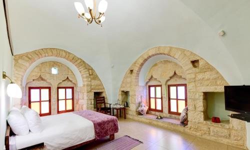 a bedroom with a bed and two arched windows at Dar Sitti Aziza in Bethlehem