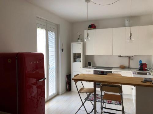 a kitchen with a wooden table and a red refrigerator at Lovely apt. only 300mt. Monza F1 Circuit-Park-Golf in Biassono