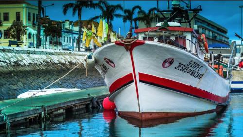 a boat is docked at a dock in the water at Sea and Marina view Apartment in Setúbal