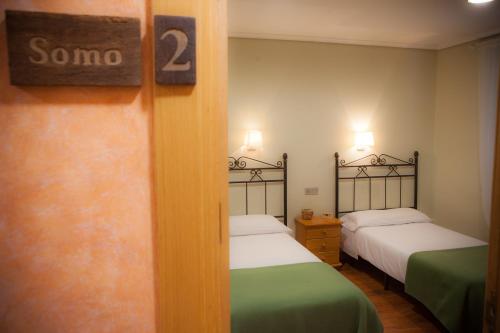 a room with two beds and a sign that says somo at Casa Rural Lagun Etxea in Pobes