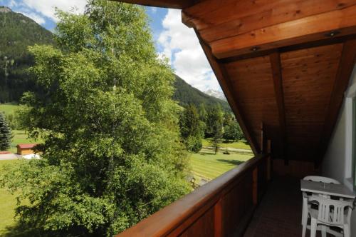 a view from the balcony of a house with a tree at Casa El Tobià in Pozza di Fassa