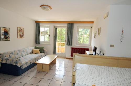 a living room with a couch and a table at Casa El Tobià in Pozza di Fassa