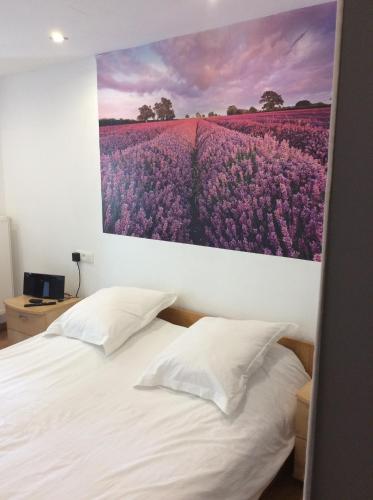 ein Schlafzimmer mit einem Gemälde von lila Blumen in der Unterkunft Hotel De Backer in Knokke-Heist
