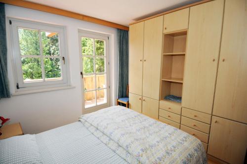 a bedroom with a bed and a window at Casa El Tobià in Pozza di Fassa