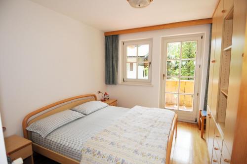 a bedroom with a bed and a window at Casa El Tobià in Pozza di Fassa