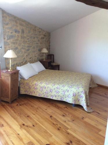 1 dormitorio con 1 cama y suelo de madera en Chambres d'hôtes Sous L'Olivier, en Trausse