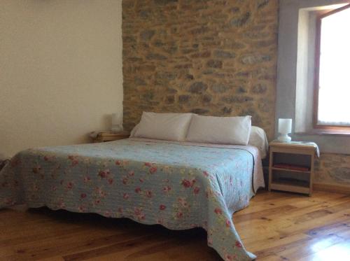 - une chambre avec un lit et un mur en briques dans l'établissement Chambres d'hôtes Sous L'Olivier, à Trausse