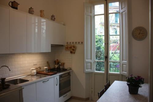 a kitchen with white cabinets and a clock on the wall at Rooms by Anna in Florence