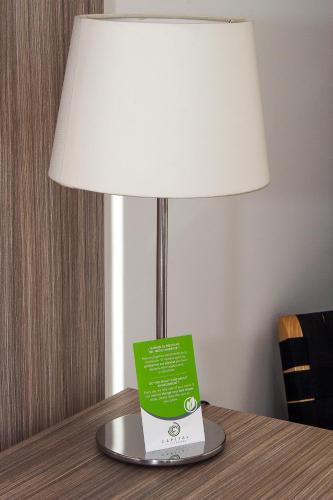 a lamp on a table with a book on it at Hotel Capital Bellet in Santiago