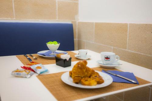 a table with a plate of food and two cups at Aegusa Hotel in Favignana