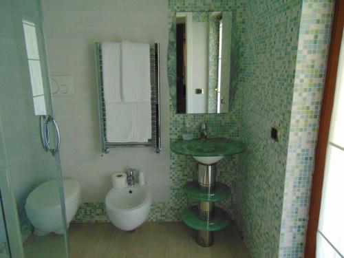 a bathroom with a sink and a toilet and a mirror at Villa Celeste B&B in Pontecagnano