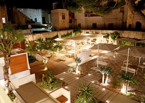 an overhead view of a patio with tables and umbrellas at night at Aegusa Hotel in Favignana